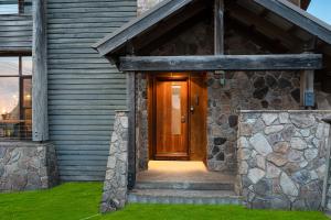 a wooden door of a house with a stone wall at Triggerplant 1 in Dinner Plain