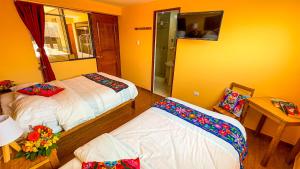 a room with two beds and a table with a mirror at Andean Atoq Hostel in Cusco