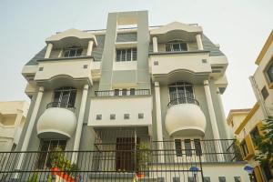 a large white building with balconies on a street at Super Collection O D'Villa in Pune