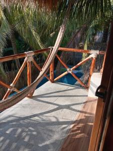 a hammock on a porch with palm trees at El Puente in El Paredón Buena Vista