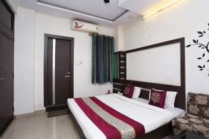 Un dormitorio con una cama grande y una ventana en OYO Hotel Kanha Palace, en Kota