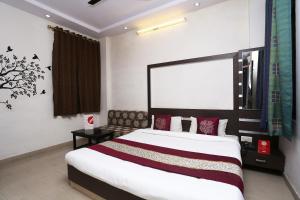ein Schlafzimmer mit einem großen Bett in einem Zimmer in der Unterkunft OYO Hotel Kanha Palace in Kota