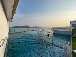 a swimming pool with a view of the water at Level 4 Simfoni Beliza , tower b in Kuah