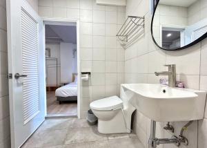 台南的住宿－燕賓大旅社，一间带水槽、卫生间和镜子的浴室