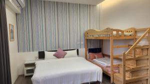 1 dormitorio con 2 literas y escalera en WanTon B&B, en Dongshan