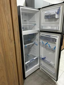 um frigorífico vazio com a porta aberta numa cozinha em Hospedaje LIZ em Tuluá