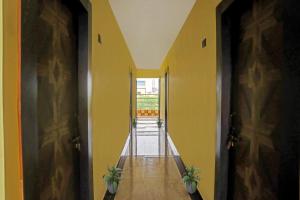 korytarz z żółtymi ścianami i dwiema drzwiami z roślinami w obiekcie Flagship Hotel Jnk w mieście Bilaspur