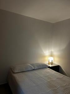 um quarto com uma cama e um candeeiro sobre uma mesa em Hospedaje LIZ em Tuluá