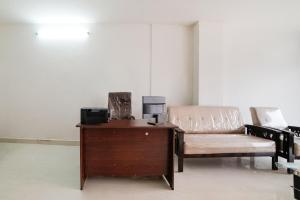 Karīmnagar的住宿－Collection O Hotel Aria Inn，一张桌子,一张沙发,一张椅子放在一个房间里