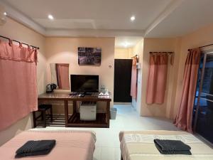 a room with a desk and a computer in it at Bansuan Sangtawan Resort in Uttaradit