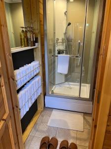 a bathroom with a shower and a glass shower stall at あそびのコテージ廿日市 in Tomota