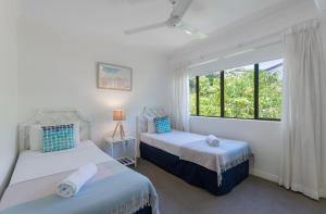 a bedroom with two beds and a window at Unit 15 @ Tropical Reef: 2 mins to Four Mile Beach in Port Douglas