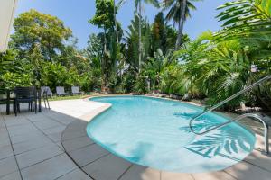 a swimming pool in a resort with a table and chairs at Unit 15 @ Tropical Reef: 2 mins to Four Mile Beach in Port Douglas +18 photos