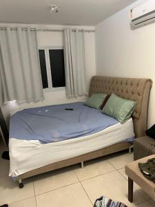 ein großes Bett in einem Zimmer mit Fenster in der Unterkunft Casa Condominio Fechado - Barra dos Coqueiros in Barra dos Coqueiros