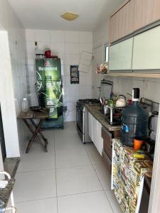 eine Küche mit einem Kühlschrank und einem Tisch darin in der Unterkunft Casa Condominio Fechado - Barra dos Coqueiros in Barra dos Coqueiros