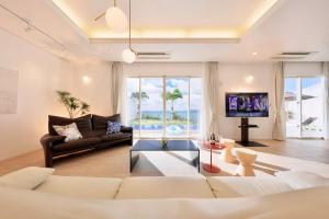 a living room with a couch and a tv at Crystal Villa Miyakojima Sunayama Beach in Miyako Island
