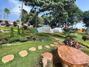 einen Park mit Zelten und einer Bank im Gras in der Unterkunft ALAM RAYA CAMP in Curug 1