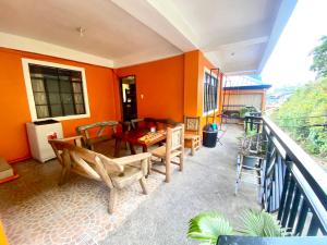 patio con mesa y sillas en el balcón en Backpackers hostel and transient house, en Nangalisan