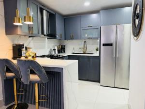 a kitchen with blue cabinets and a stainless steel refrigerator at Family Fun Vacation In Paradise in Santiago de los Caballeros