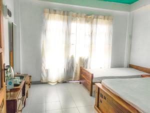 um quarto com 2 camas e uma janela em The Pearl Homestay em Nugatalawa