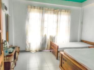 NugatalawaにあるThe Pearl Homestayのベッド2台と窓のある寝室
