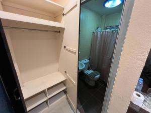 a small bathroom with a toilet and a shower at Bansuan Sangtawan Resort in Uttaradit