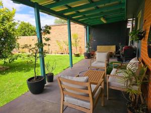 a patio with two chairs and a table at Tranquil and cosy guest house in Oakleigh East