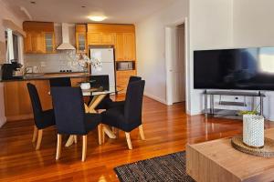 a kitchen and dining room with a table and chairs at Tranquil and cosy guest house in Oakleigh East