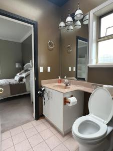 a bathroom with a toilet and a sink and a bed at V.I.P. CLUB in Surrey