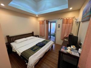a bedroom with a large bed and a television at Bansuan Sangtawan Resort in Uttaradit