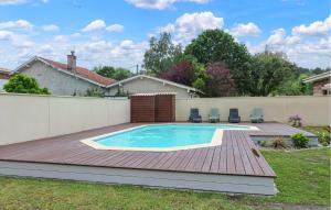 un patio trasero con piscina y terraza de madera en Beautiful Home In Mios With Outdoor Swimming Pool, en Mios