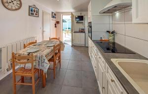 cocina con mesa, sillas y reloj en Beautiful Home In Mios With Outdoor Swimming Pool, en Mios