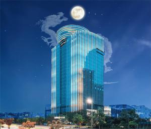 Un palazzo alto con una luna sopra di Echeng Hotel - Huawei Base Store in Shenzhen a Shenzhen