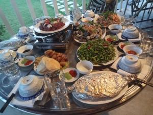 a table with many plates of food on it at The River Home in Nhơn Trạch