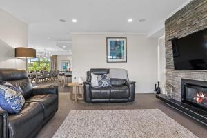 a living room with leather furniture and a fireplace at Eagles Nest - Kinloch in Kinloch