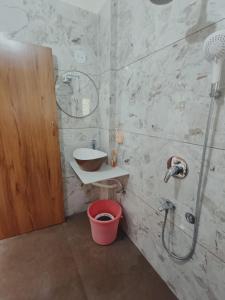 y baño con ducha, lavabo y cubo. en DR BHOIR FARM & RESORT, en Kalyan