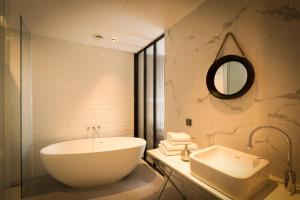 a bathroom with a tub and a sink and a mirror at Trang Blue Hotel in Seoul