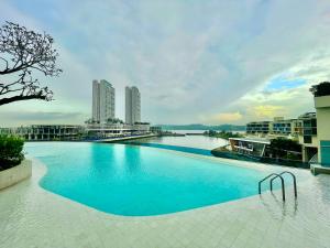 a large swimming pool with a view of a city at PineTree Puteri Harbour @ UHA in Nusajaya