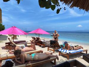 a group of people laying on the beach at Lushy Hostel Nusa Penida in Nusa Penida