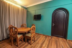 une salle à manger avec une table, des chaises et une télévision dans l'établissement Hill Rows Estate, à Vayittiri