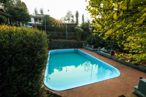 a swimming pool in a yard with the sun setting at Hill Rows Estate in Vayittiri