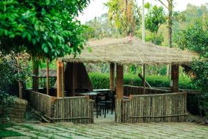 a patio with a table and a straw umbrella at Hill Rows Estate in Vayittiri