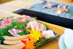 un plato de comida con carne y verduras en una mesa en 四万十川傍にある日本家屋まるごと「貸切宿　ほとり」, en Shimanto