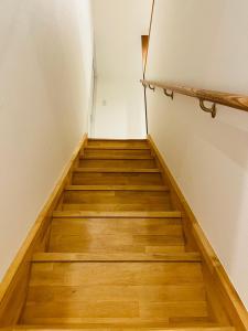 a staircase in a room with wooden floors at 奥武島の浅築マンション 1フロア貸し切り BBQ可能 短い橋で島へアクセス テラスで海を楽しむ coco アイランド in Shikenbaru