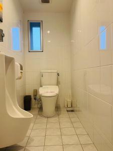 a white bathroom with a toilet and a sink at 奥武島の浅築マンション 1フロア貸し切り BBQ可能 短い橋で島へアクセス テラスで海を楽しむ coco アイランド in Shikenbaru