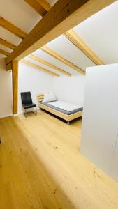 1 dormitorio con 1 cama y 1 silla en una habitación en Kohlis Alpine Home en Bruck an der Großglocknerstraße