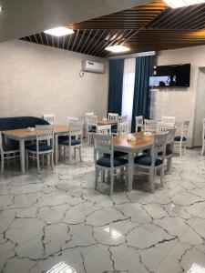 een eetkamer met tafels en stoelen op een tapijt bij Ibn Sino Hotel in Bukhara