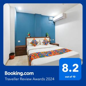 1 dormitorio con 1 cama con pared azul en FabHotel Usha Continental, en Muthiganj