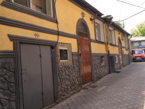 un bâtiment jaune avec des portes brunes dans une rue dans l'établissement Bazar Motel, à Chişinău