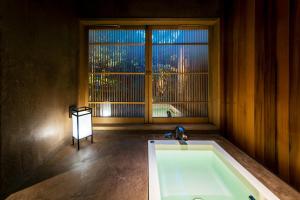 a bath tub in a room with a window at Choya Chawanzaka Machiya House in Kyoto